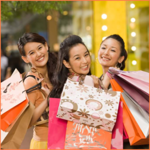 Three Chinese ladies carrying luxury brand shopping bags